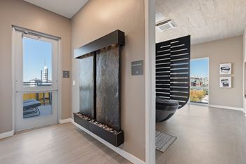 A modern room with a large window and a fireplace.